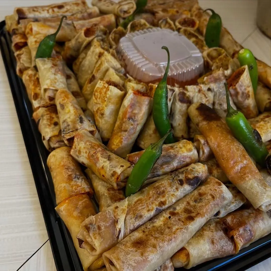 Charola de burritos dorados con chiles verdes hechos con tortilla de harina